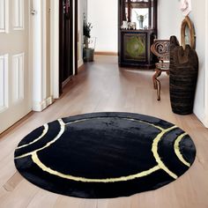 a large black rug in the middle of a wooden floored hallway with white walls