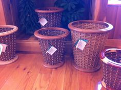 four brown wicker baskets sitting on top of a wooden floor