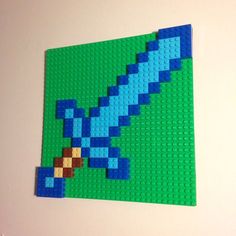 a piece of lego art made to look like a blue bird on a green background