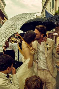 a man and woman kissing under an umbrella