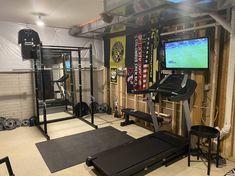 a home gym with treadmills, exercise equipment and a flat screen tv on the wall