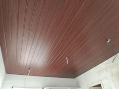 an unfinished room with wood paneling on the ceiling