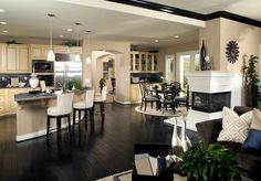 a kitchen and dining room with hardwood flooring in the middle, along with an island