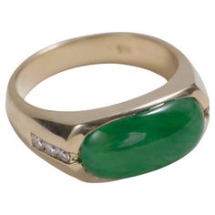 This classic and substantial jade saddle ring features a vivid, highly translucent cabochon of certified untreated emerald green Burmese jadeite jade that is cut into the rectangular "saddle" shape you see here. The saddle ring is perhaps the most quintessential jade ring. This one is unusual, however, for its exceptionally fine stone. The 14k yellow gold mounting holds three small but very white and clean diamonds on each shoulder for an emphatic sparkle that doesn't overwhelm. Measuring approx Modern Cabochon Emerald Ring For Formal Occasions, Modern Formal Emerald Cabochon Ring, Formal Green Polished Gemstones, Modern Jade Cabochon Jewelry, Formal Oval Jade Emerald Ring, Fine Jewelry Jade Rings With Polished Finish, Modern Formal Emerald Ring With Oval Cabochon, Modern Oval Jade Ring, Classic Jade Rings With Polished Finish