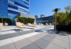 lounge chairs are lined up on the roof of an office building