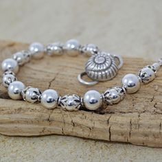 Elevate your boho chic style with this lovely beachy accessory featuring a stunning Thai conch shell closure. This handcrafted beaded bracelet combines the beauty of bohemian design with coastal style. Alternating sterling silver round beads are capped with Bali sterling silver and finished with an S-style Thai clasp. Orders ship Monday - Friday via US First Class mail. Processing time is 1 - 2 days; most items ship the same day. Thank you for choosing BeadedMoonJewery for your jewelry needs. If you hav questions or customization requests, please feel free to message me. I take pride in providing high-quality, unique pieces that you'll cherish for years to come. Bohemian Pearl Bracelet For Summer, Summer Bohemian Pearl Bracelet, Adjustable Silver Beaded Bracelets For Beach, Adjustable Silver Bohemian Pearl Bracelet, Adjustable Silver Pearl Bohemian Bracelet, Adjustable Silver Pearl Bracelet In Bohemian Style, Bohemian Silver Beaded Bracelets For Beach, Bohemian Silver Beads Jewelry For Beach, Silver Bracelets With Round Beads For Summer