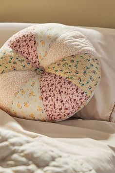 a round pillow sitting on top of a bed