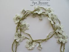 a close up of a necklace with flowers on it