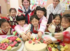 a group of people standing around a cake