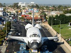 an airplane is parked on the side of the road in front of a city street