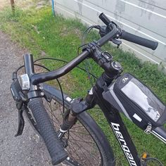 a close up of the handlebars on a bicycle with a bag attached to it