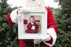 a santa clause holding up a photo frame