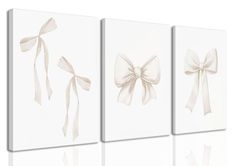 three white paintings with bows on them