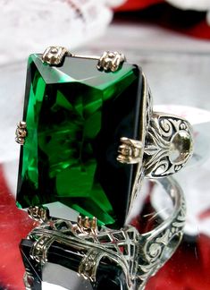 Simulated Green Emerald Ring  6 Prong Design#104 Custom Made to Order I now offer this is a brand new 1930's Art Deco reproduction ring in solid sterling silver. The gorgeous filigree ring is set with a flawless huge 30ct Man-made/simulated dark green emerald gemstone. The high quality rectangle cut gem is 20mm in length by 15mm in width (5/8th inch by 11/16th inch). The inside of the band is marked 925 for sterling silver. Notice the beautiful swirl like craftsmanship of the silver filigree set Emerald Statement Ring, Emerald Art, Art Deco Emerald Ring, Smaragd Ring, 1930s Style, Sophisticated Art, Stock Design, Prong Ring, Green Emerald Ring