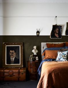 a bed room with a neatly made bed and two pictures on the wall above it