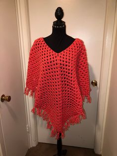 This poncho is done in Red Heart yarn in the color Flamingo. It measures 29" long in the front and back with the fringe and 24"long in both arms with the fringe.  shipping is free with this item. Long Sleeve Fringe Poncho, Red Long Sleeve Poncho, One Size, One Size Poncho With Tassels In Cape Shape, One Size Shawl Poncho With Fringe, One Size Fringe Shawl Poncho, Red Fringed Shawl For Fall, Red Fringe Shawl For Fall, Red Bohemian Poncho With Fringe, Spring Fringe Poncho One Size