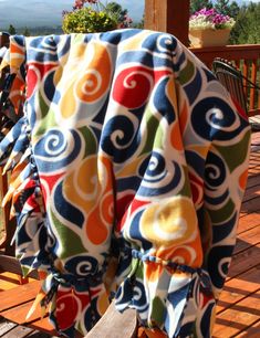 a colorful blanket sitting on top of a wooden bench