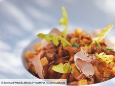 a white bowl filled with food on top of a table