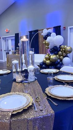 a table set with plates, silverware and balloons