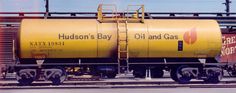 a yellow oil tank sitting on top of train tracks