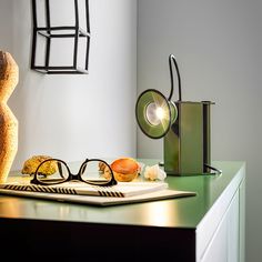 a pair of glasses sitting on top of a table next to a vase and lamp