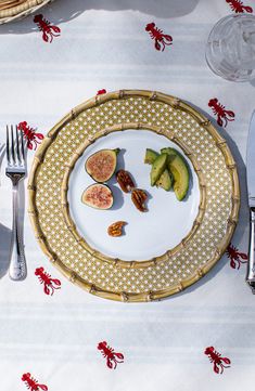 a white plate topped with cut up avocados on top of a table next to a knife and fork