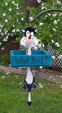 a black and white cat holding a blue box with what bird? written on it