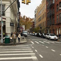 people are standing at an intersection waiting to cross the street