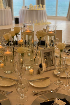 the table is set with candles, plates and silverware for an elegant wedding reception