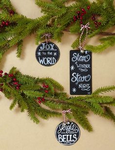 three ornaments hanging from a christmas tree with the words joy to the world on them