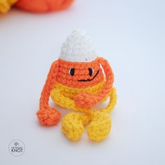 an orange crocheted toy with a white hat