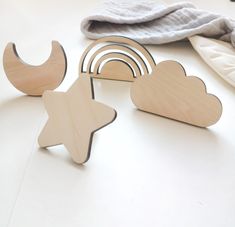 several wooden toys sitting on top of a white table next to some blankets and pillows