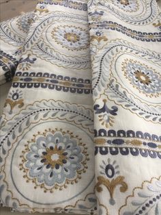 an image of a white and blue fabric with gold designs on it's edges