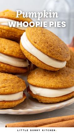 pumpkin whoopie pies stacked on top of each other with cinnamon sticks in the background