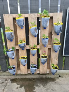 a wooden pallet filled with potted plants and hanging planters on it's sides