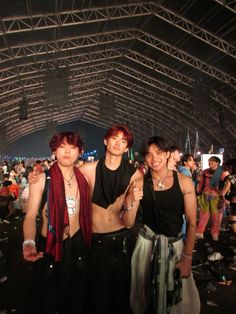 three young men standing next to each other under a tent