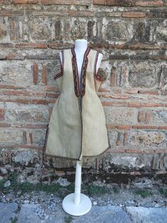 This is a a long vest, also known as 'klashenik' and also as 'resacka' part of the women's ethnic costume from the south western part of Macedonia, Struski Drimkol. This vest was made in the second half of XIX century and is really rare piece of the ethnic costume from this region. The vest has a few damages visible on the photos, a hole at the back side, few damages on the embroidery on the sleeves and a discoloring from washing on some places and that's the reason the price is much lower than Handmade Folk Style Vest For Festivals, Handmade Folk Vest For Festivals, Fitted Beige Bohemian Vest, Bohemian Fitted Beige Vest, Fitted Bohemian Beige Vest, Folk Style Fitted Festival Vest, Folk Style Sleeveless Festival Vest, Traditional Ceremonial Sleeveless Vest, Vest Handmade