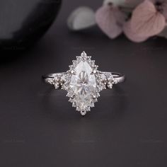 an engagement ring with a pear shaped diamond center