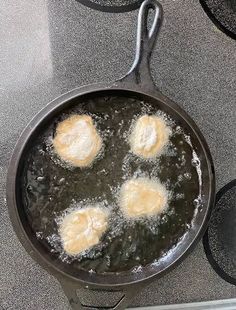 three eggs frying in a skillet on the stove