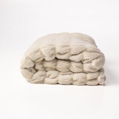 a pile of white blankets folded on top of each other in front of a white background