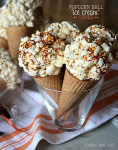 ice cream cones filled with popcorn and sprinkles in a clear glass cup