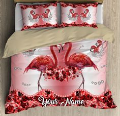 two flamingos are standing next to each other on a bed with red and white sheets