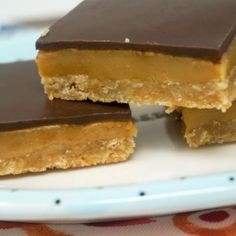 three pieces of chocolate peanut butter bars on a plate