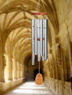 a wind chime hanging from the side of a building with arches in the background