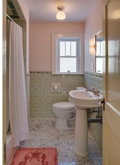 a bathroom with pink walls and white fixtures