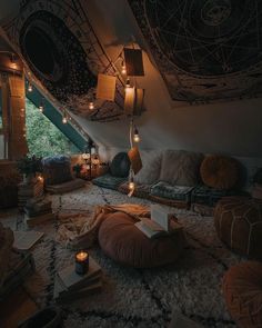 a room with lots of pillows and lights on the ceiling is lit up by candles