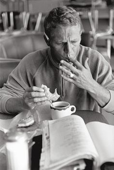 a man sitting at a table with an open book in front of him and reading the text reading essex