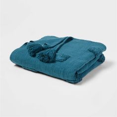 a teal blanket with tassels on it