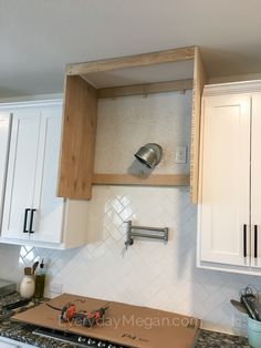 a stove top oven sitting inside of a kitchen next to white cabinets and counter tops