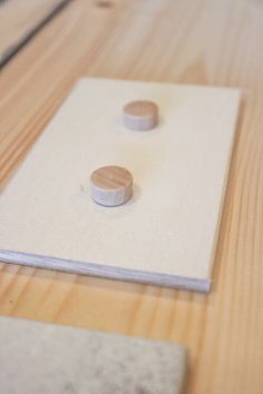 two wooden buttons sitting on top of a piece of paper